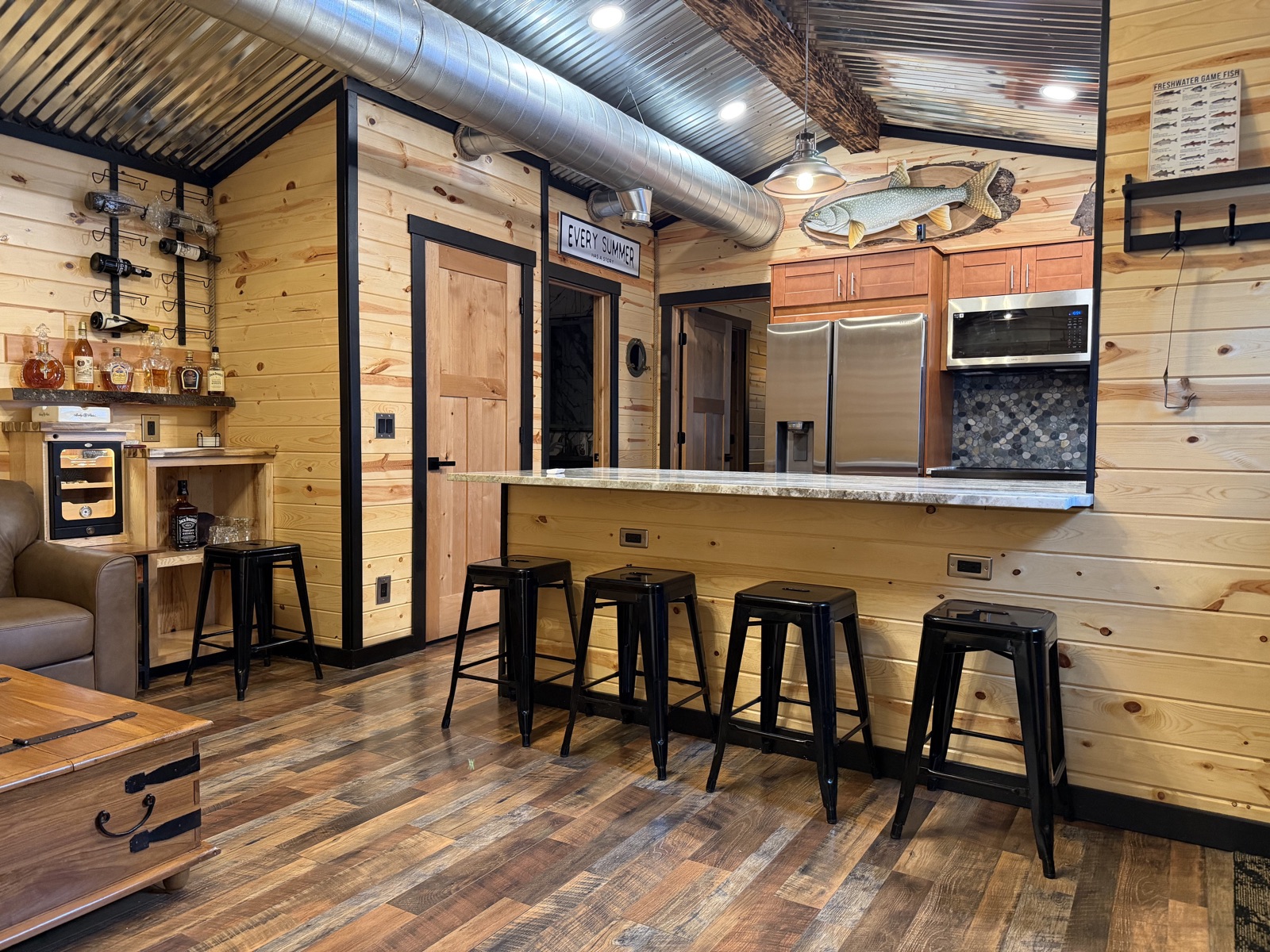 Fisher Cottage — kitchen and bar seating under a corrugated-metal ceiling