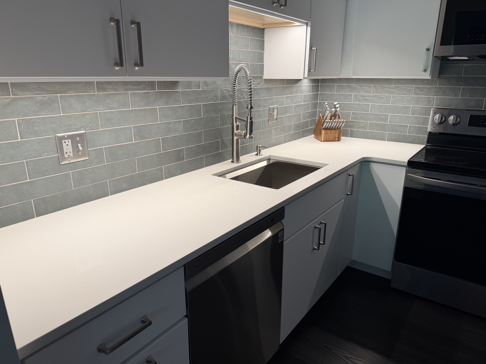 Sycamore Kitchen — quartz counter, sage subway tile backsplash, and integrated LG appliances